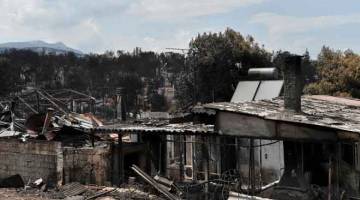 SALAH SIAPA?: Pemandangan rumah terbakar di resort tepi pantai Mati, wilayah timur Attica selepas kebakaran maut melanda kawasan itu. Maklumat yang ‘serius’ untuk ‘perbuatan jenayah’ yang menyebabkan kebakaran telah mengorbankan sekurang-kurangnya 87 orang dalam kebakaran hutan paling teruk di negara ini, menurut perdana menteri Greek, kelmarin. — Gambar AFP