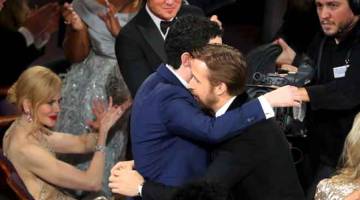 TURUT TERCALON: Gambar fail menunjukkan Ryan Gosling (kanan) memeluk Damien Chazelle semasa diumumkan sebagai Pengarah Terbaik di Anugera Oscar pada awal tahun ini. Filem baharu Damien Chazelle, ‘First Man’, yang dibintangi pelakon dari Kanada, Ryan Gosling turut tercalon di festival filem Venice.   — Gambar Reuters