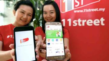 PELANCARAN: Penolong Pengurus Pemasaran Komunikasi 11Street Lim Ai Yen (kiri) dan Chen Pelf Yeen menunjukkan aplikasi 11Street selepas Taklimat Revolusi Baharu 11Street di Menara 1 Sentrum di Kuala Lumpur, kelmarin. — Gambar Bernama