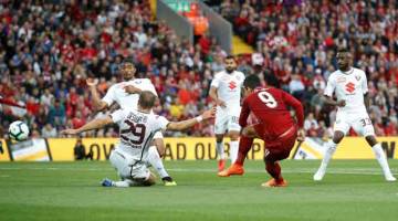 AKSI MEYAKINKAN: Firmino melepaskan rembatan sebelum menjaringkan gol pertama The Reds di Anfield, Liverpool kelmarin. — Gambar Reuters