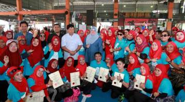 UNTUK ALBUM: Rina (berdiri tengah) bergambar bersama usahawan tempatan pada Program Menyantuni Tranformasi Luar Bandar anjuran Persatuan Usahawan Muslimah Johor di Sport Prima Pandan di Johor Bahru, semalam. — Gambar Bernama