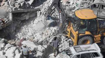 MUSNAH: Pekerja penyelamat Syria menggeledah runtuhan bangunan kelmarin ekoran letupan di depoh senjata di kawasan                 kejiranan Sarmada di wilayah Idlib, utara Syria. — Gambar AFP