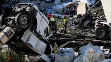 MISI MENYELAMAT: Penyelamat memeriksa runtuhan di bawah jambatan Morandi di bandar pelabuhan Genoa, Itali, yang roboh pada Selasa lalu. — Gambar Andrea Leoni/AFP