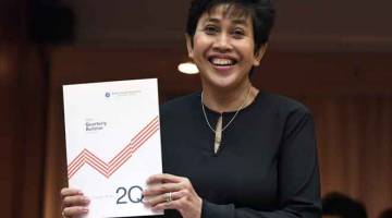 LENGKAP: Nor Shamsiah menunjukkan buku ‘BNM Quarterly Bulletin’, semalam. — Gambar Bernama