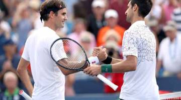 BAKAL BERSUA: Gambar fail bertarikh 18 Ogos ini menunjukkan Federer (kiri) dan Djokovic berjabat tangan selepas tamat aksi perlawanan di Lindner Family Tennis Center di Mason, Ohio. — Gambar AFP 