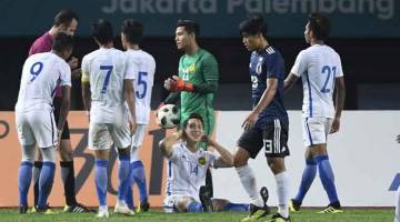 APAKAN DAYA: Pengadil, Bijan Heidari menghadiahkan sepakan penalti kepada pasukan Jepun selepas Dominic Tan Jun Jin menjatuhkan pemain Jepun dalam kawasan Malaysia pada bola sepak Sukan Asia Jakarta-Palembang 2018 di Stadium Patriot Chandrabaga Mamat Bekasi di Jakarta malam kelmarin. — Gambar Bernama