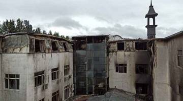 MUSNAH: Pemandangan sebuah hotel selepas kebakaran yang mengorbankan sekurang-kurangnya 18 orang di Harbin, ibu kota wilayah timur laut Heilongjiang, semalam. — Gambar AFP 