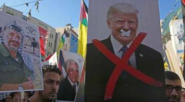 TIDAK PUAS HATI: Penunjuk perasaan Palestin membawa potret arwah pemimpin Palestin Yasser Arafat dan Presiden AS Donald Trump semasa rapat umum untuk menyokong pergerakan Fatah di Nablus, Tebing Barat. — Gambar AFP