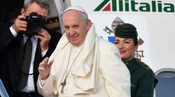 JALANKAN TANGGUNGJAWAB: Pope Francis melambai tangan ketika beliau memasuki kapal terbang untuk perjalanan pastoral dua hari ke Ireland kelmarin dari lapangan terbang Fiumicino. —Gambar AFP