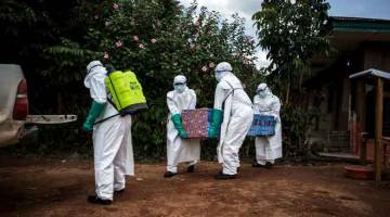 KAWALAN KETAT: Pekerja kesihatan membawa keluar badan pesakit yang belum diketahui disahkan dijangkiti virus Ebola baru-baru ini di Mangina, di Beni, wilayah Utara Kivu. — Gambar AFP