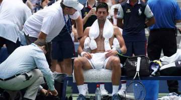 SUHU TINGGI: Djokovic meletakkan tuala ais selepas diberikan rehat selama 10 minit ketika beraksi menentang Fucsovics pada pusingan pertama Terbuka AS di New York, Amerika Syarikat Isnin lepas. — Gambar AFP.  — Gambar AFP