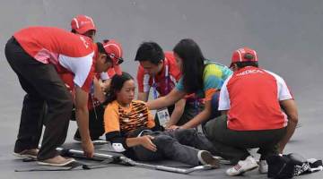 CEDERA: Grace dibantu anggota paramedik setelah mengalami kecederaan ketika sesi memanaskan badan sebelum memulakan pusingan akhir acara Park Wanita Sukan Asia 2018 di Stadium Papan Selaju Bandar Sukan Jakabaring, Palembang semalam. — Gambar Bernama