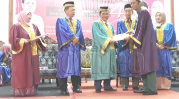 ARIFIN (tiga kiri) menyampaikan anugerah kepada salah seorang graduan pada majlis konvokesyen itu. Turut kelihatan Hasbullah (tiga kanan).