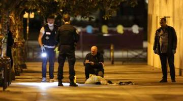 SIASAT: Polis memeriksa tapak di mana seorang lelaki menyerang tujuh orang di jalan raya di Paris kelmarin. — Gambar Zakaria Abdelkafi/AFP 