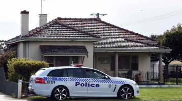 LOKASI JENAYAH: Kereta polis dilihat di luar sebuah rumah di mana polis menemui lima mayat di subbandar berhampiran bandar barat daya Perth semalam. — Gambar Greg Wood/AFP