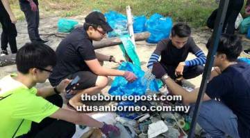 JAGA KEBERSIHAN PANTAI: Sukarelawan bergotong-royong mengutip sampah di pantai Matang.