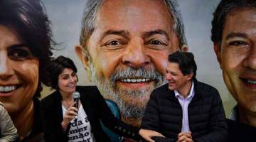 CALON PILIHAN: Gambar fail menunjukkan Haddad (kanan) dan D’Avila bercakap di hadapan gambar Lula pada sidang media di Sao Paulo, Brazil pada 7 Ogos lalu. — Gambar Nelson Almeida/AFP