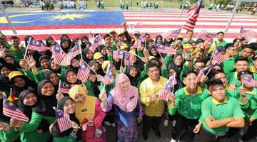 Affida ( tiga kiri) merakamkan gambar  bersama warga SMK Taho berlatar belakangkan replika Jalur Gemilang gergasi daripada dulang telur terpakai. - Gambar Chimon Upon