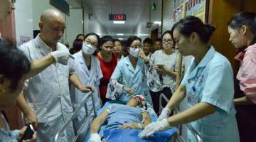 PARAH: Gambar yang dirakam kelmarin menunjukkan pekerja perubatan memindahkan mangsa yang cedera di hospital selepas kereta dipandu oleh seorang lelaki merempuh sebuah dataran awam yang sesak di Hengdong, wilayah Hunan, tengah China. — Gambar AFP