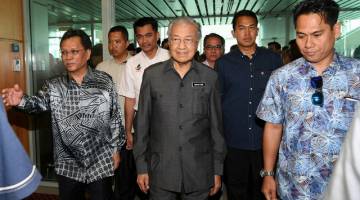 Dr Mahathir (depan, tengah) diiringi Ketua Menteri Sabah Datuk Seri Mohd Shafie Apdal (kiri) sebaik tiba di Lapangan Terbang Antarabangsa Kota Kinabalu kira-kira 12.20 tengah hari tadi. - Gambar Bernama 