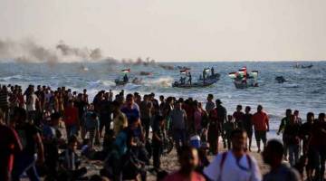 TETAP BANTAH: Penduduk Palestin mengadakan protes menuntut pengunduran sekatan rejim Israel ke atas Semenanjung Gaza, di tepi pantai di Beit Lahia dekat sempadan maritim dengan Tel Aviv kelmarin. — Gambar AFP