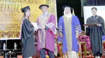 YUSOF (dua kiri) menyampaikan sijil kepada salah seorang graduan pada majlis itu.