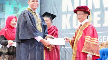 SHAFIE (kanan) menyampaikan sijil kepada salah seorang graduan pada Majlis Konvokesyen Kolej Komuniti Negeri Sabah 2018.
