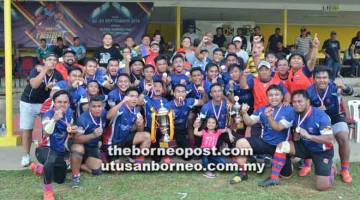 PENUH BERMAKNA: Dr Hazland bersama pasukan juara, Kuching pada Kejohanan Ragbi 15s Piala Presiden 2018 di Padang Ragbi Song Kheng Hai, Kuching semalam.