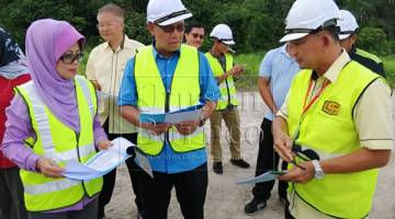 Fatimah (kiri), Julaihi (tengah) ketika diberikan taklimat mengenai projek Jalan Tanam-Medong pada lawatan.