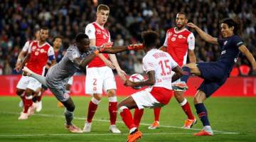 GEGAR JARING: Cavani (kanan) menjaringkan gol ketiga PSG pada aksi liga menentang Reims di Parc des Princes, Paris pada Rabu lepas. — Gambar Reuters