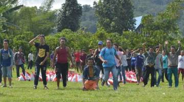 LEGA: Penduduk menunggu helikopter tentera berlepas sebelum mendapatkan bantuan yang telah dihantar kepada mereka di kampung Proo, daerah Lindu dalam bahagian Sigi, Sulawesi tengah semalam yang turut terkesan bencana gempa bumi dan tsunami pada 28 September lalu. — Gambar AFP