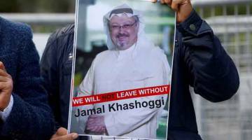 BANYAK PERSOALAN: Seorang penunjuk perasaan membawa gambar Khashoggi semasa mengadakan protes di hadapan konsulat Arab Saudi di Istanbul, Jumaat lalu. — Gambar Reuters