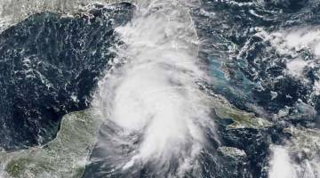 MENGGERUNKAN: Imej satelit NOAA/RAMMB yang dirakam kelmarin menunjukkan kemaraan Michael di luar pantai Teluk AS. — Gambar AFP