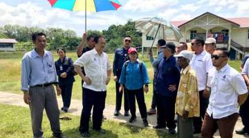 KEMUDAHAN PENDUDUK: Wong (dua kiri) dan Christina (tiga kiri) meninjau tapak cadangan pembinaan Klinik Desa di Kampung Pulau Tetabuan semalam. — Gambar Bernama