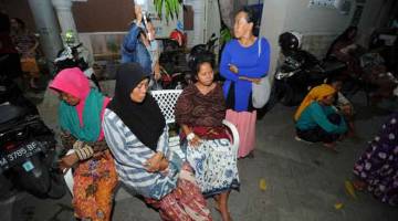 BERTENANG: Pesakit dilihat duduk di sebuah kawasan terbuka selepas kejadian gempa bumi,                    di hospital Larasati di Pamekasan, Indonesia, semalam. — Gambar Antara/Reuters