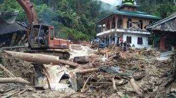 OPERASI MENYELAMAT: Jentera berat digunakan untuk mengalih puing selepas banjir kilat melanda perkampungan Saladi di Mandailing Natal, Sumatra Utara, semalam. — Gambar AFP