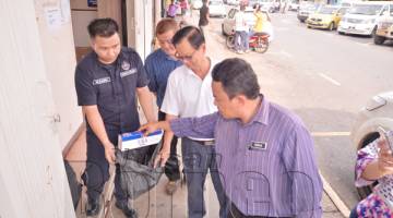 PETER Hii bersama Pegawai Penguatkuasa MPS Irman Tajuddin Edy memeriksa rokok yang dijumpai diletak di tepi dinding bangunan.