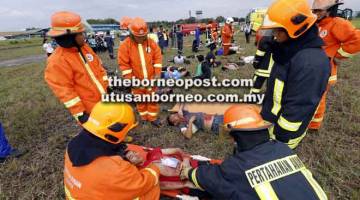 TINGKAT KECEKAPAN: Anggota APM membantu penumpang ‘Brotherhood Airlines’ sementara menunggu bantuan seterusnya daripada anggota paramedik dalam latihan tersebut.