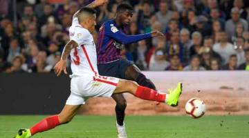 LEDAKAN PADU: Dembele (kanan) melakukan percubaan dari luar petak penalti Sevilla ketika beraksi pada perlawanan La Liga di Nou Camp, Barcelona Sabtu lepas. — Gambar Reuters