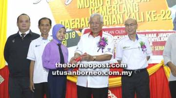 TAHNIAH: Manyin menyampaikan anugerah cemerlang kepada salah seorang pelajar pada  Majlis penyampaian Anugerah Pelajar Cemerlang Peringkat Daerah Serian Ke-22.