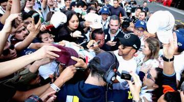 DISERBU PEMINAT: Hamilton melayan kerenah peminatnya semasa tiba di Mexico untuk Formula Satu Grand Prix Mexico di Autodromo Hermanos Rodriguez, Mexico City. — Gambar AFP