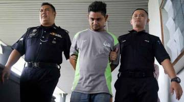 BERSALAH: Md Zhafran (tengah) diiringi keluar oleh dua pegawai Polis di Mahkamah Sesyen Melaka semalam selepas mengaku bersalah atas enam pertuduhan melakukan amang seksual fizikal terhadap dua remaja lelaki dan menyebabkan kedua-dua mangsa melihat video lucah. — Gambar Bernama