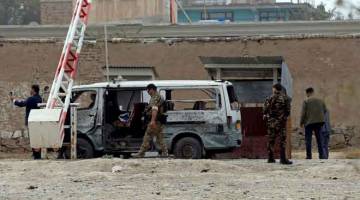 SIASAT: Anggota pasukan keselamatan memeriksa tapak serangan bom berani mati di Kabul, Afghanistan kelmarin. — Gambar Reuters