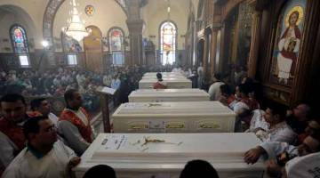 SUASANA PILU: Orang ramai berhimpun untuk pengebumian Kristian Koptik yang terbunuh dalam satu serangan, di Gereja Putera Tadros di Minya, Mesir semalam. — Gambar Reuters