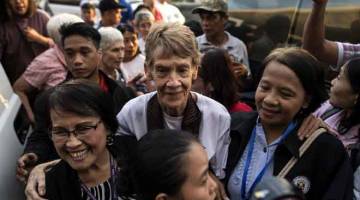 SEBAK: Fox dikerumuni para penyokong sebaik tiba di balai perlepasan Lapangan Terbang Antarabangsa Manila di Manila, kelmarin. — Gambar AFP