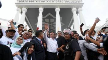 Mohd Shafie melambaikan tangan kepada penyokongnya selepas diumumkan sebagai Ketua Menteri Sabah yang sah oleh Mahkamah Tinggi Kota Kinabalu hari ini. - Gambar Bernama 