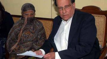 SUDAH BEBAS: Gambar fail yang dirakam pada 20 November 2010 ini dan dikeluarkan oleh                      Rumah Gabenor Punjab menunjukkan Taseer (kanan) menyerahkan dokumen kepada Asia Bibi  di Penjara Pusat di Sheikhupura. — Gambar AFP
