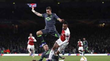PENUH AKSI: Antara babak-babak aksi perlawanan Liga Europa di antara Arsenal dan Sporting di Stadium Emirates, di London. — Gambar AFP
