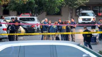 CARI PETUNJUK: Anggota FBI menyiasat lokasi kejadian tembakan beramai-ramai di sebuah bar di Thousand Oaks, California, Amerika Syarikat kelmarin. — Gambar Reuters