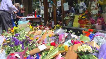 BERI PENGHORMATAN TERAKHIR: Orang ramai memberi penghormatan terakhir kepada mangsa kejadian tikaman di tengah Melbourne semalam. — Gambar Reuters